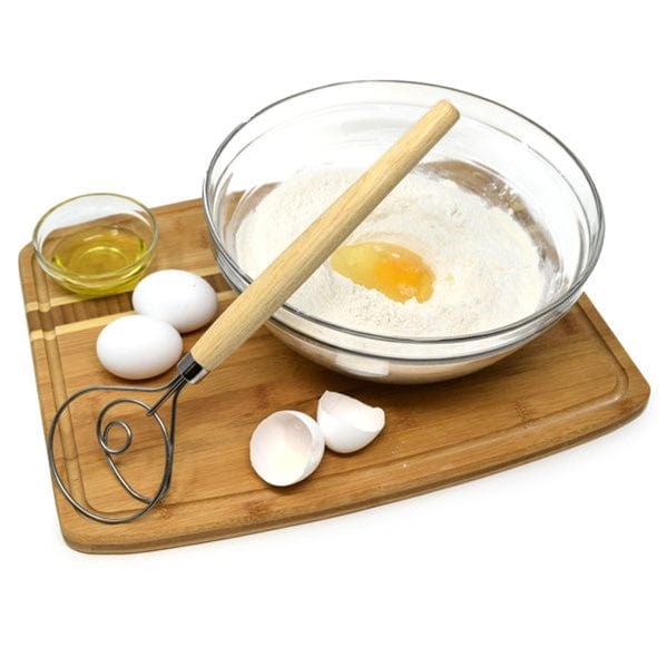 Norpro 12'' Danish Dough Whisk next to two eggs, broken eggshells, a glass cup of oil, and a mixing bowl with egg and dry ingredients for sourdough inside