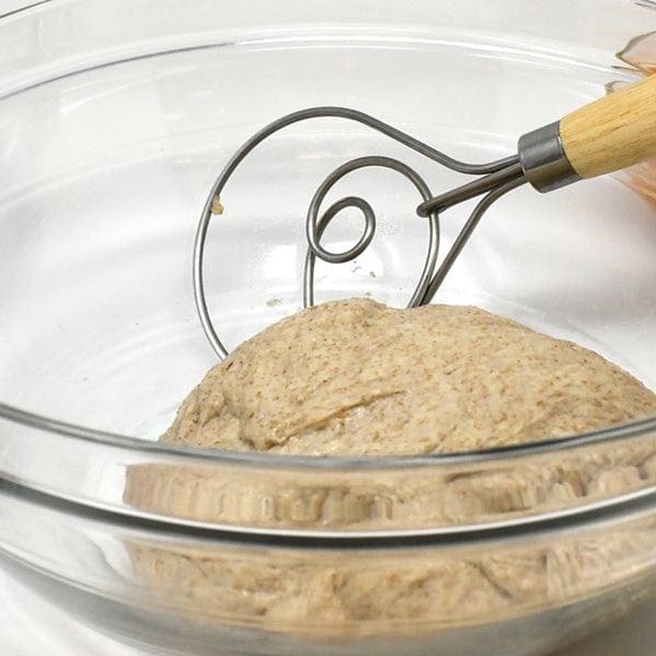 closeup of Norpro 12'' Danish Dough Whisk mixing sourdough dough inside glass mixing bowl