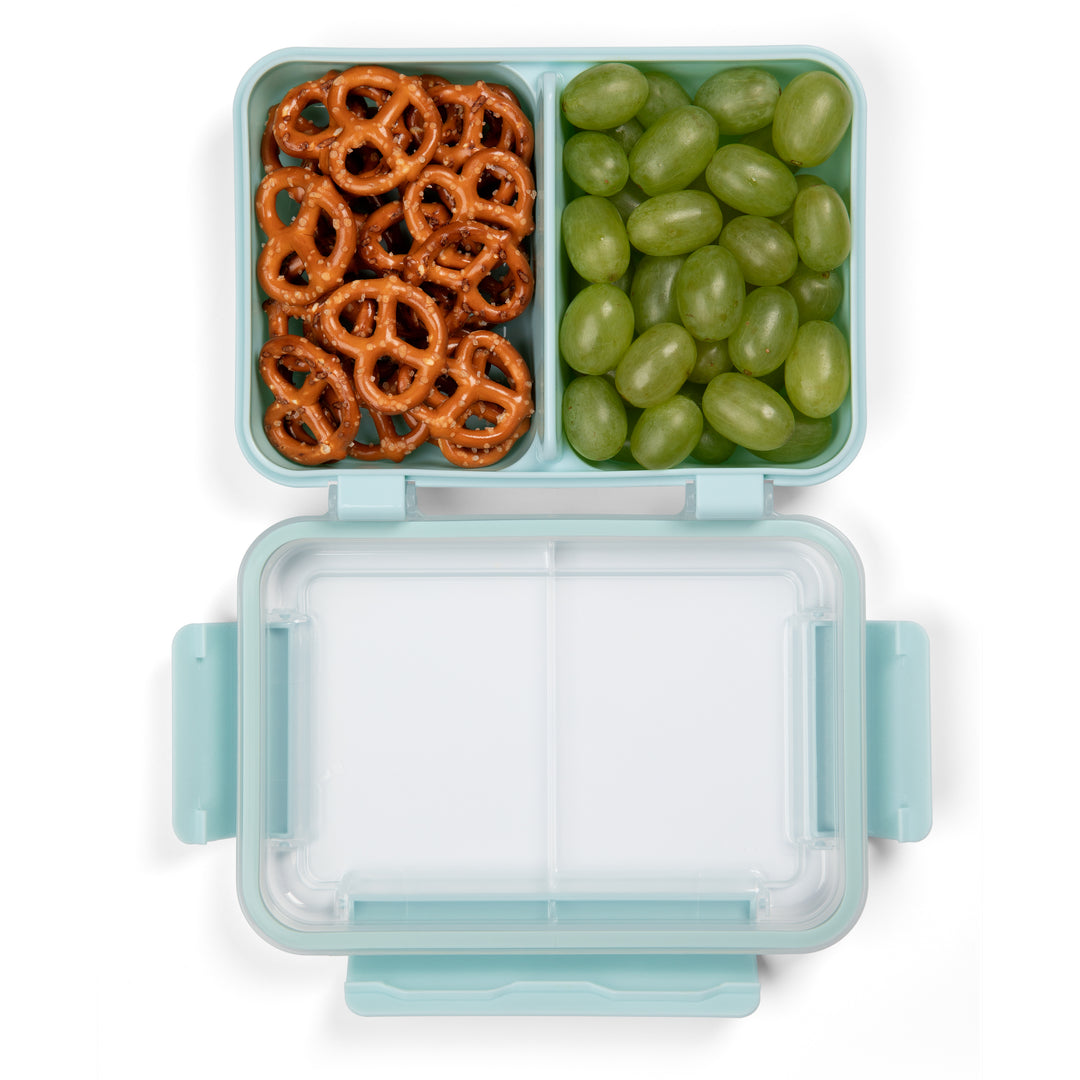 top view of light blue plastic food container for lunch and snacks with open lid and divider separating pretzels and green grapes