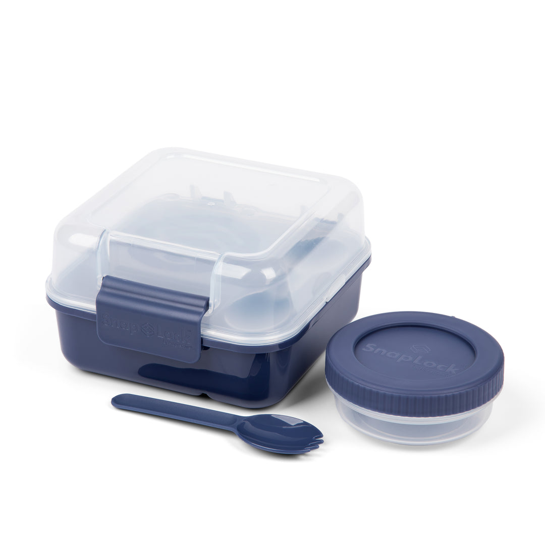 navy blue plastic lunch box for food storage with compartments including two box pieces, a salad dressing cup, and a spork