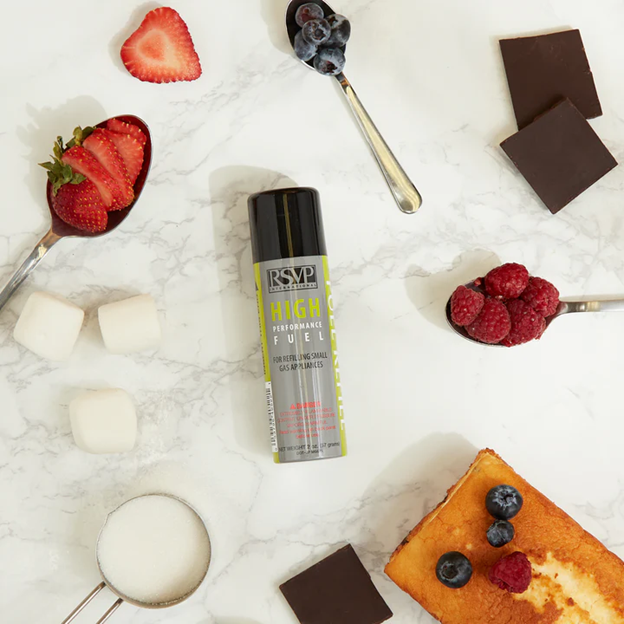 refillable butane fuel can surrounded by creme brulee ingredients including strawberries, blueberries, dark chocolate, butter, and sugar