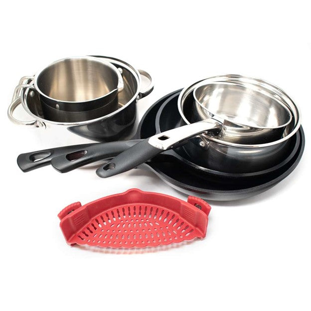 red silicone clip on kitchen strainer in front of two stacks of silver pots and black pans