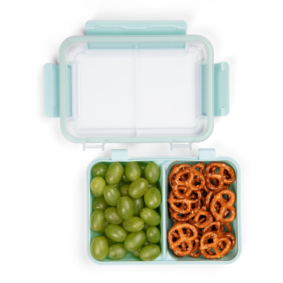 top view of light blue plastic snack box container with lid off of container and divider separating green grapes and pretzels