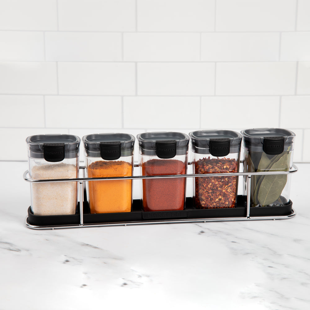 spice containers with spices in rack on counter