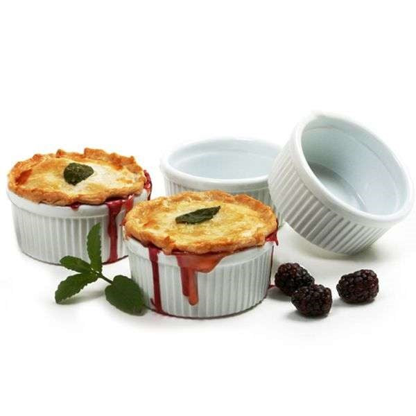 four white porcelain brulee ramekin dishes with pie and three blackberries